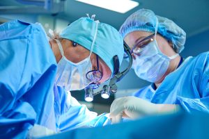 A surgeon's team in uniform performs an operation on a patient at a cardiac surgery clinic. Modern medicine, a professional team of surgeons, health