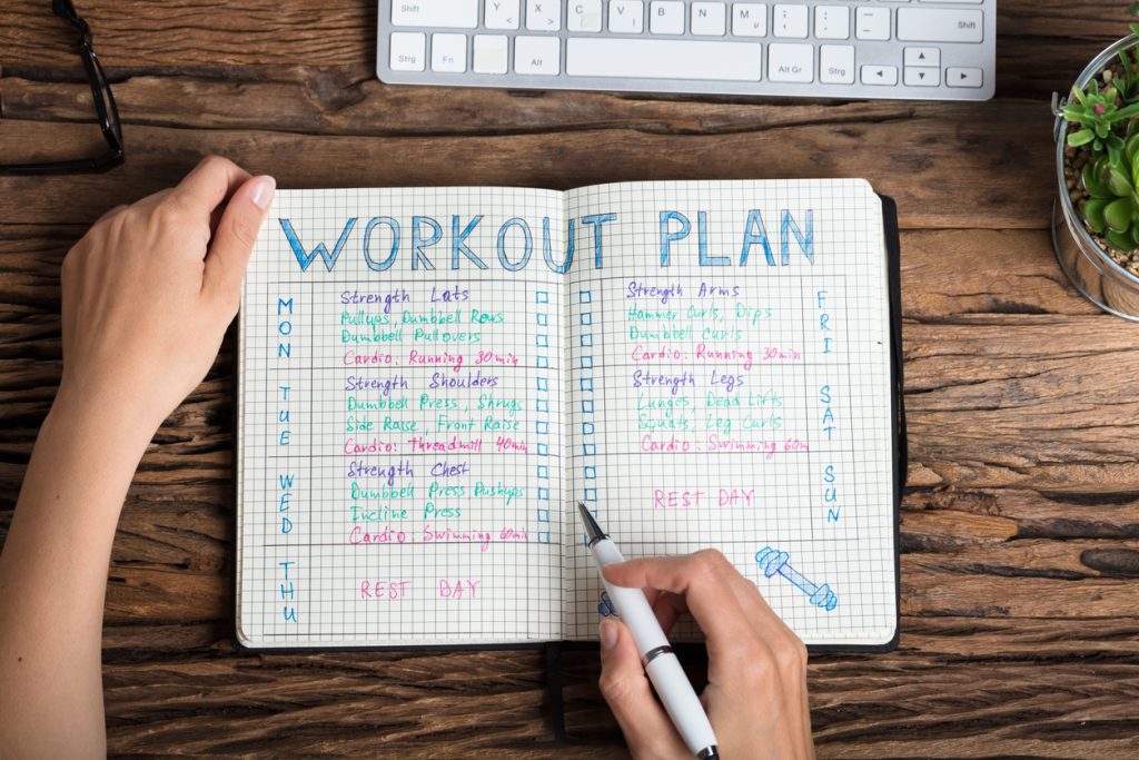 workout plan written out in a journal with fun colored pens