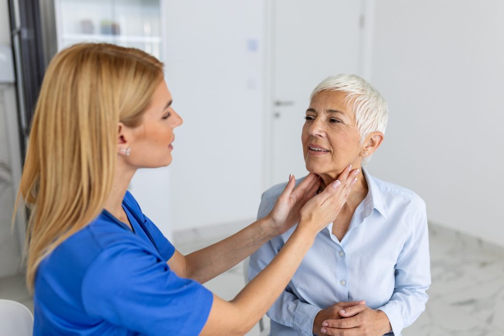 doctor looking at patient with thyroid issue